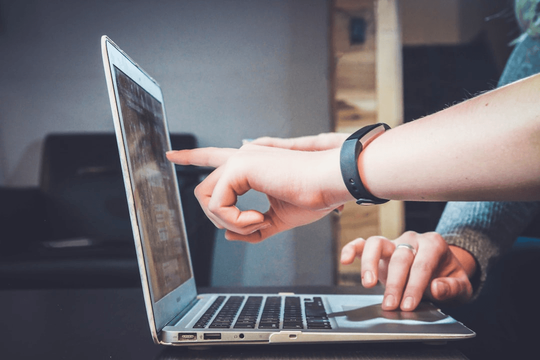 Hands working over a desk with notes and a laptop in cool light