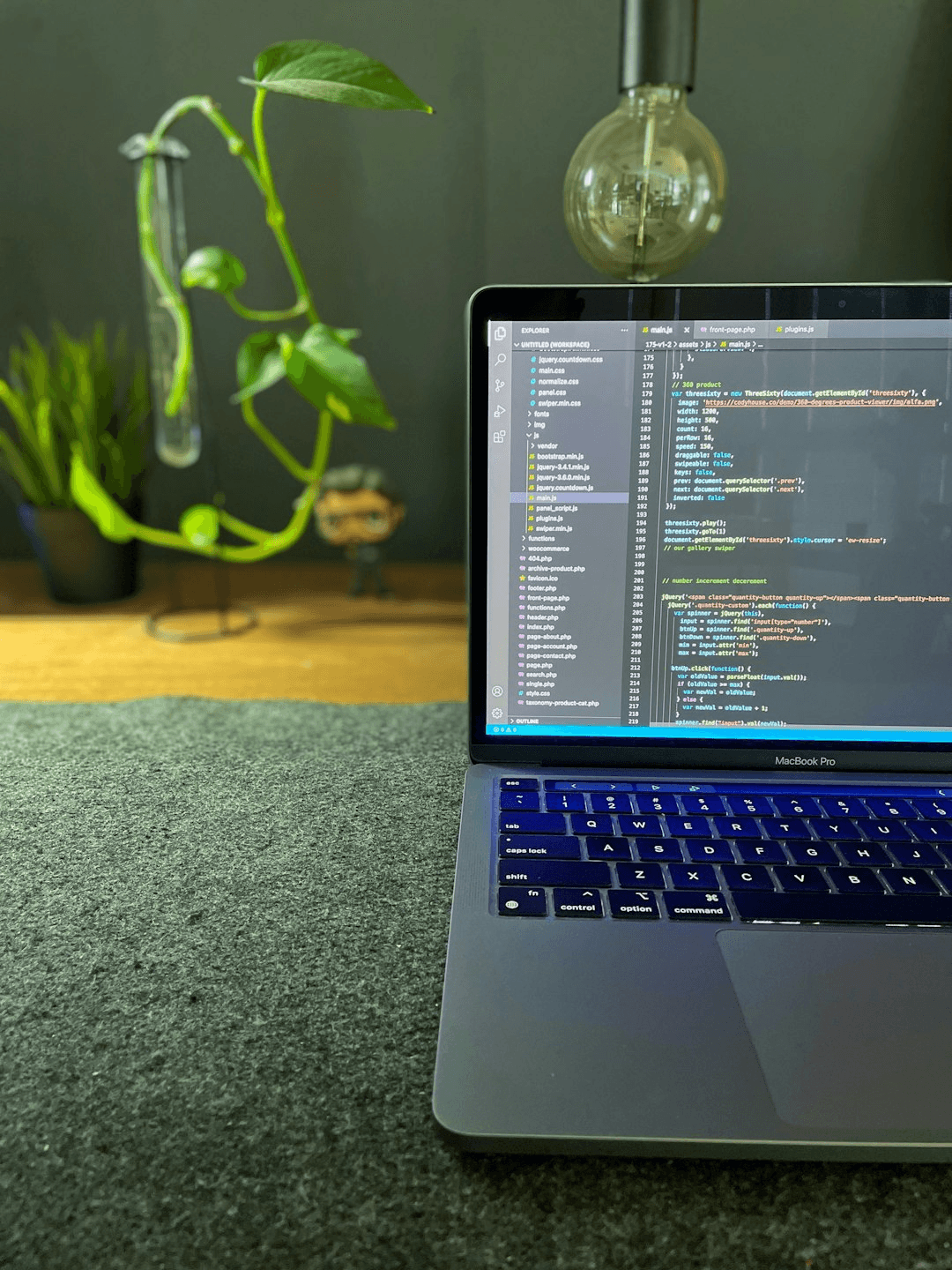 Coding setup lit with warm yellow light and an abstract neon sketch
