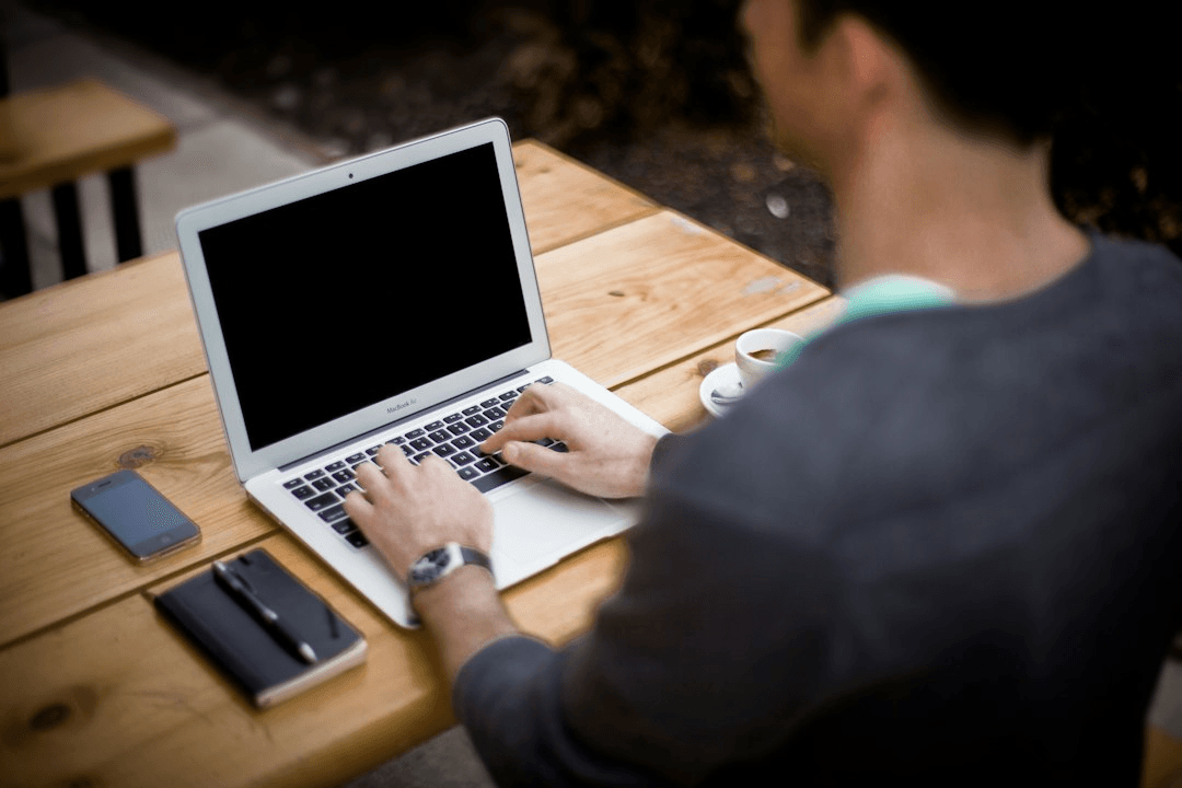 Person working with a laptop at a table in warm evening light